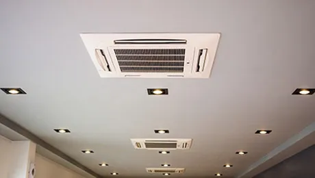 Ceiling cassette air conditioners set into an office ceiling
