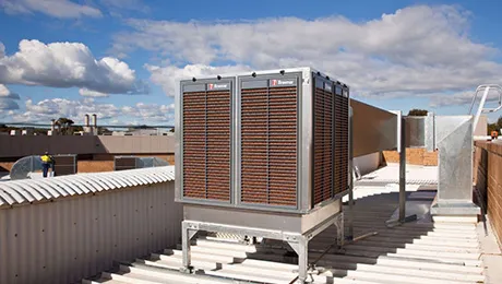 Rooftop evaporative cooler unit under a blue sky