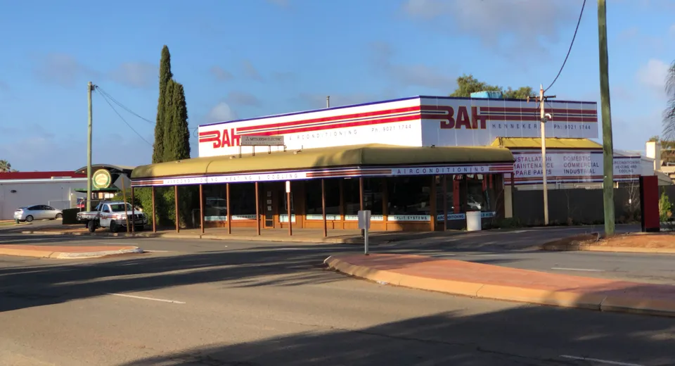 The BAH Henneker & Co shop at golden hour, red-striped BAH signs on the roofline
